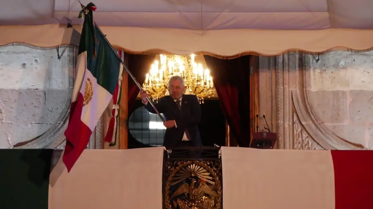 Alfredo Ramírez Bedolla ondeando la Bandera de México